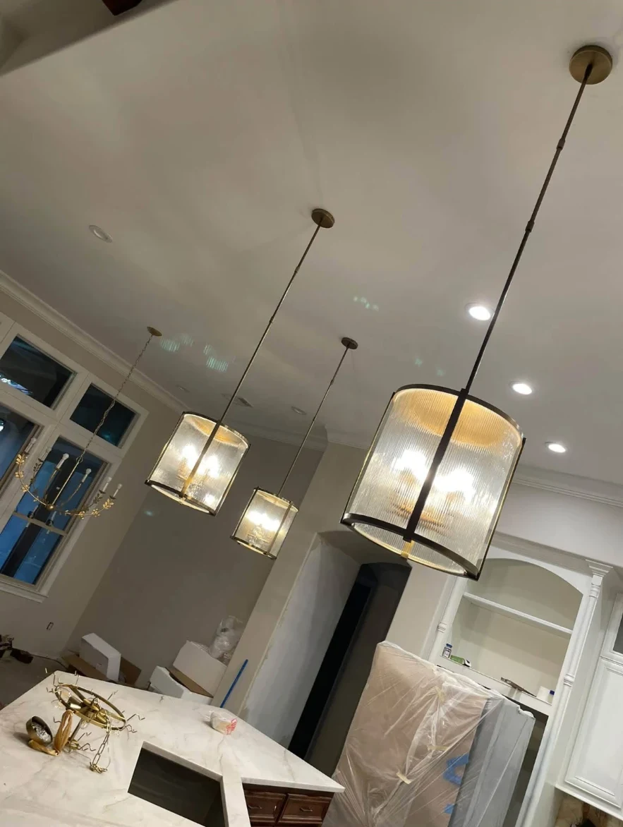 Ribbed glass pendant lighting installed over a quartzite island